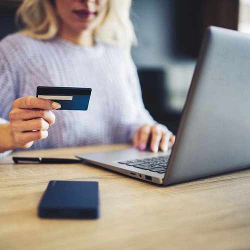Woman Shopping Online With Her Credit Card In Her Hand